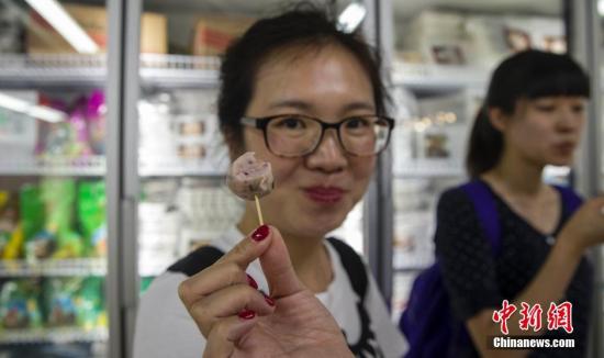 6月29日，北京国内首家供港生鲜门店内，首批试吃的顾客展示从广东阳江运来的鱼丸。供港生鲜是指从内地专门为港澳提供鲜活冷冻食品，至今已经历经54年历程，建立了一套规范的出口食品质量安全保障规范。近来在国家质检总局等部门支持下，供港生鲜企业和产品按照同线同标要求回归内地。7月1日，全国首家供港生鲜门店将在北京开店，一些从南海水域出产的食品来到北京“赶考”，首次接受内地消费者的考验。 <a target='_blank' href='http://www.chinanews.com/'>中新社</a>记者 张浩 摄