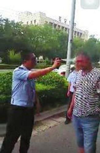 违停车主不满处理拍打警车 被交警用喷雾放倒