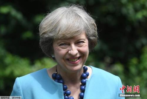 当地时间2016年7月14日，英国伦敦，英国首相特蕾莎·梅在府邸花园中举办警察勇敢奖招待会。当日，“时尚女教主”梅姨选择了蓝色系套装，配上曾出镜过的蓝色项链。