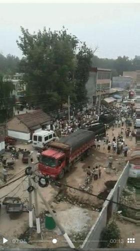 现场有一辆货车、两辆特警车以及一辆交通执法车，多名群众聚集在车辆旁边。 来源：视频截图