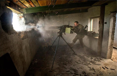 图为乌政府军士兵在民房中使用Dshk重机枪猛烈开火。