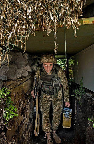 分别手持AK步枪和弹药箱的乌政府军士兵在掩体中留影。