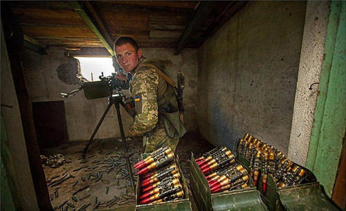 在掩体中作战的乌军机枪手，可见满装的弹药箱。