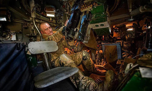 坦克兵在炮塔内调试武器。