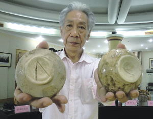 图为闻长庆展示刻有类希腊字母的古越青瓷器。（南华 摄） 