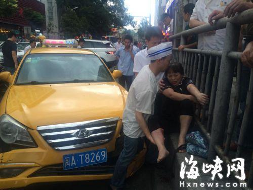 丈夫用身体顶住车子，一手托着妻子的伤腿 