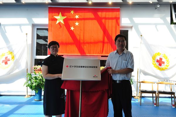 北京首家红十字生命健康安全体验教室落户北京灯市口小学，中国红十字会总会赈济救护部救护处张立副调研员与灯市口小学滕亚杰校长共同为体验教室揭牌