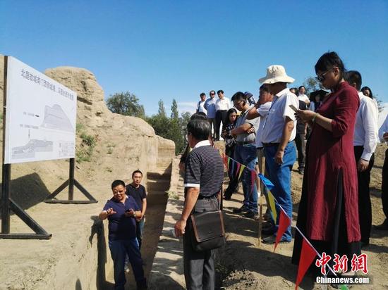 图为专家现场讲解北庭故城南门西侧城墙文物挖掘情况。中新社记者 王小军 摄