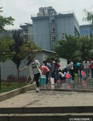图为学生排队提水。