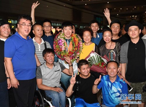里约残奥会乒乓球冠军葛杨（中）在首都国际机场与人们合影留念。 新华社记者贺长山摄 图片来源：新华网