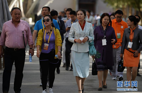 一名身着全新工作制服的莫高窟讲解员带领游客参观。 新华社记者 陈斌 摄 图片来源：新华网