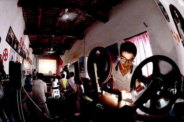 0028四留固是南吕固乡的一个村，这个村的出名，完全是因为村里出了个电影收藏家魏少先，很多人都跑来参观他的电影博物馆。图为老魏的小儿子在播放红色影片