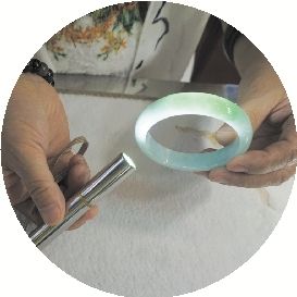 经营一家文玩宝石店的店主黄海燕展示品质较好的翡翠手镯。