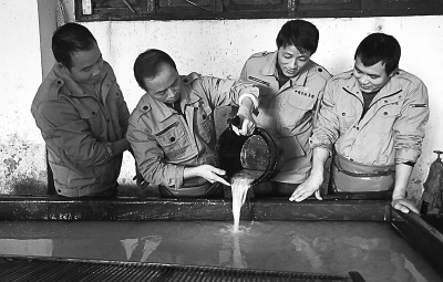 周东红(左二)与工友们交流捞纸经验 周东红(左二)与工友们交流捞纸经验