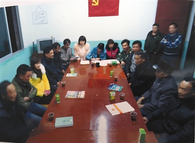 庄里村两委开会时的照片，图中穿迷彩服者是周炳耀。这是他为数不多的工作照之一。