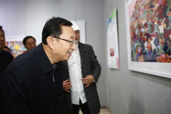 雒树刚部长认真观看农民画