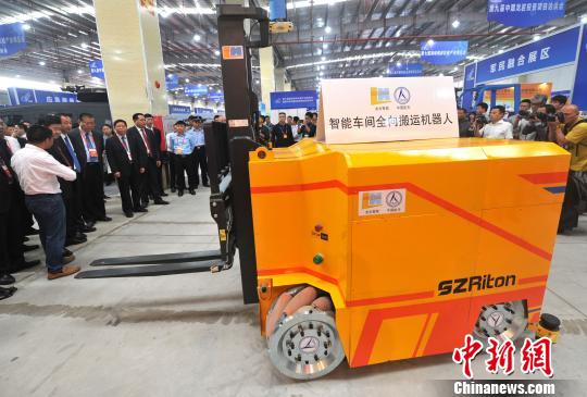 图为与会领导嘉宾参观智能车间全向搬运机器人。　张斌 摄