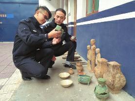 昨日，兴平市公安局刑侦大队东城中队，民警查看被追缴回来的文物 华商报记者 薛望 摄