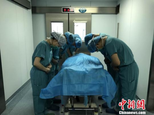 器官摘除手术结束后，医护人员向杨先松的遗体默哀致敬?！±蠲?摄