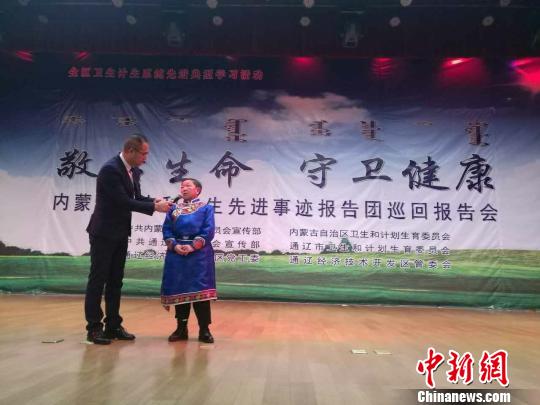 图为哈申通拉嘎在报告会现场接受采访?！⊥跞鸱?摄