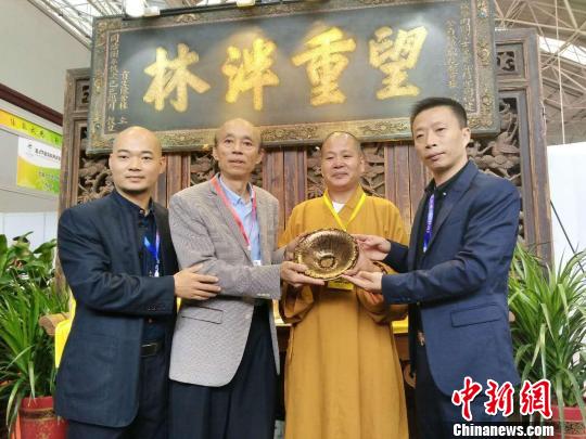 由中国高级工艺美术师，非物质文化遗产建盏技艺传承人黄美金（左二）创作的金油滴撇口盏，被来自福建福清的著名慈善家陈先生和万福禅寺方丈悲升大师（右二）以299万元购得?！±罴恿帧∩? style=