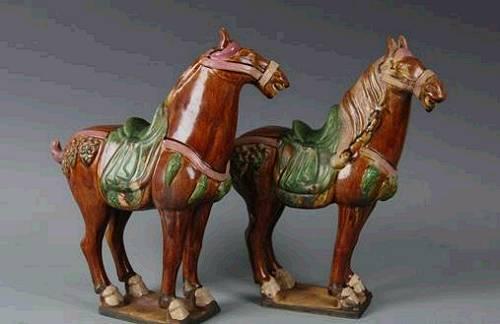 这款“马到成功”开运双件套叫做“唐三彩”，其实是唐代的“冥器”，是唐代用来陪葬的东东。唐代厚葬之风盛行，又不能像秦始皇兵马俑那样摆那么大阵势，就用陶瓷烧出很多马来下葬，让墓主在阴间也有马可骑。