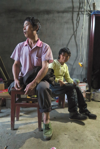 11月20日下午，范家发向来访者介绍自己的家庭情况，身后是他的妻子。