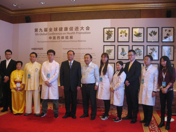 五、王国强与中医药体验展的工作人员留影。 人民政协网记者  张春莉  摄影