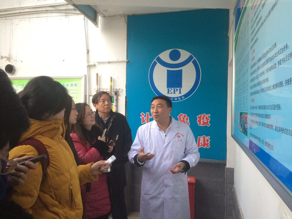 陕西省安康市茨沟镇中心医院院长晏显兴（右）在向记者介绍如何破解农村医疗难题。后排右二为陕西省卫生计生委副主任陈昭。人民政协网记者张春莉  摄