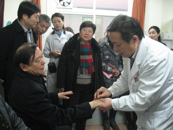 二、陕西省卫生计生委副主任陈昭（左）于调研现场亲身体验碑林区东关南街社区医院医生的针灸技艺。人民政协网记者  张春莉