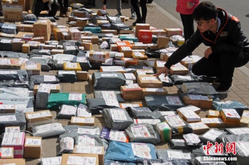 资料图：山西太原一高校外，学生们在地摊上找寻各自的快递。武俊杰 摄