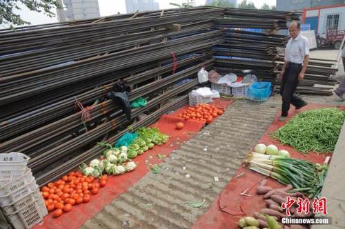资料图:山西太原民众在街头一处用钢筋围成的菜铺内购买蔬菜。<a target='_blank' href='http://www.chinanews.com/'>中新社</a>发 武俊杰 摄 点击进入下一页