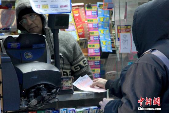 资料图:纽约曼哈顿一彩票售卖点人们排队购买彩票。 <a target='_blank' href='http://www.chinanews.com/'>中新社</a>记者 阮煜琳 摄 点击进入下一页