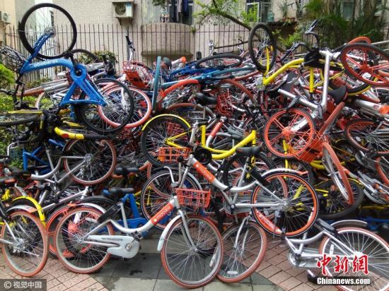 2017年1月16日，广东深圳南山区，深圳蛇口湾厦山公园出入口，出现大面积人为破坏的共享单车。几种品牌的数百辆共享单车堆积成两座“小山”，或因外力破坏等原因，不少单车的车把、车篮等零件散落在周围地上，一片狼藉。 图片来源：视觉中国