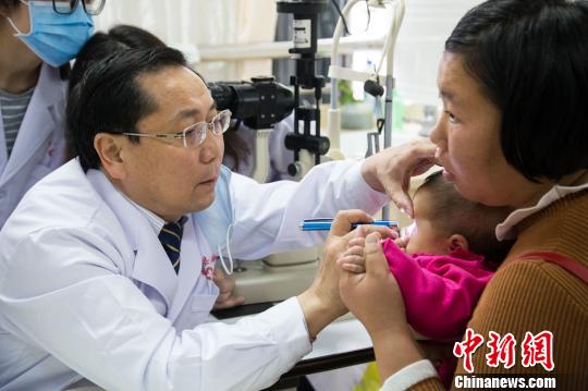 亢泽峰(左)为幼儿义诊?！±钅闲?摄