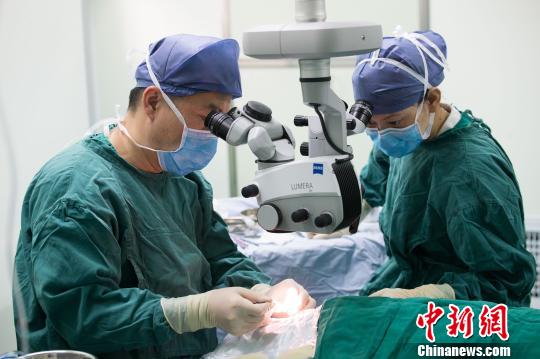 中国中医科学院眼科医院眼科主任医师、教授林涛(左)为留守老人做白内障手术?！±钅闲?摄