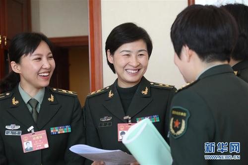 3月7日，全国人大代表刘洋（左二）等在解放军代表团小组会议间隙交流。在两会会场内外，女代表、女委员、女工作人员、女记者在工作中尽职尽责，展现着自己的风采。 新华社记者 李刚 摄