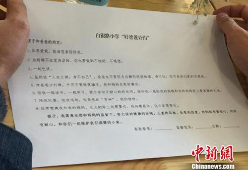 图为家长阅读“好爸爸公约”?！×跤裉?摄