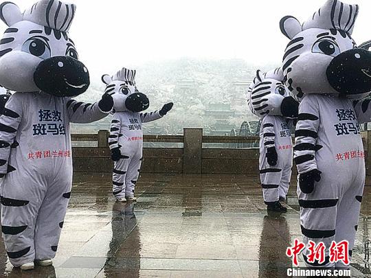 图为伴随着欢快的音乐，多名志愿者化身的“斑马卫士”做着“交通手势操”?！∈肪簿?摄