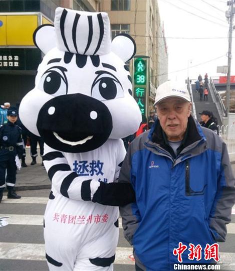 “斑马卫士”在十字路过摇晃着胖胖的身躯，搀扶老人过斑马线。　钟欣 摄