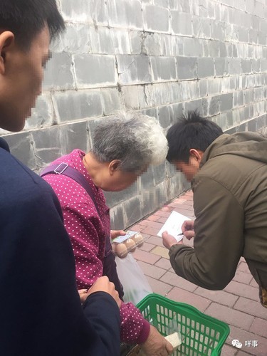 有老人上前询问，经理上前登记派发团购券。