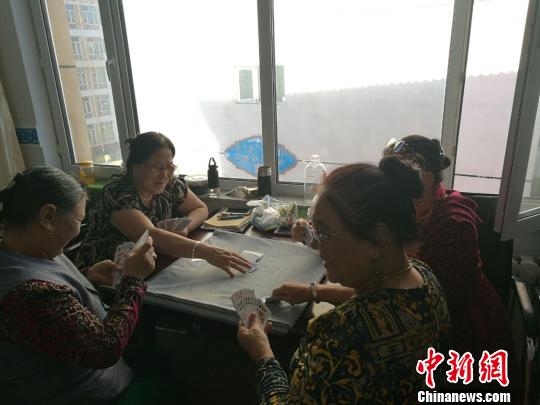 图为进城牧民在一起打扑克?！±畎?摄