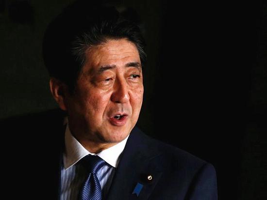 3月16日，日本首相安倍晋三走在东京官邸内。（新华/路透）