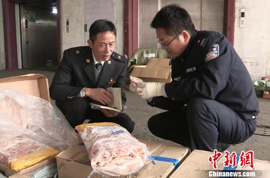 图为海关关员与缉私警察正在仓库清点被扣冻品?！⊙钗?摄