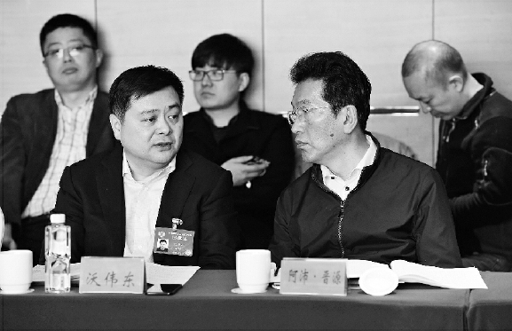 今年两会期间，阿沛·晋源（右）在界别小组讨论会上。    本报记者  齐波  摄
