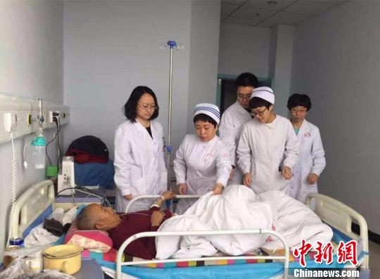 景玮(左一)带领的扶贫医疗队正在阳高县人民医院查房?！》独龇?摄