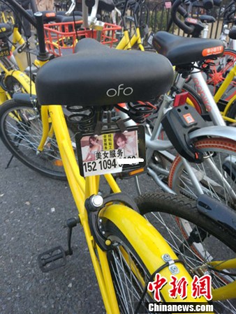 一辆共享单车上的小广告。<a target='_blank' href='http://www.chinanews.com/' >中新网</a>记者 李金磊 摄