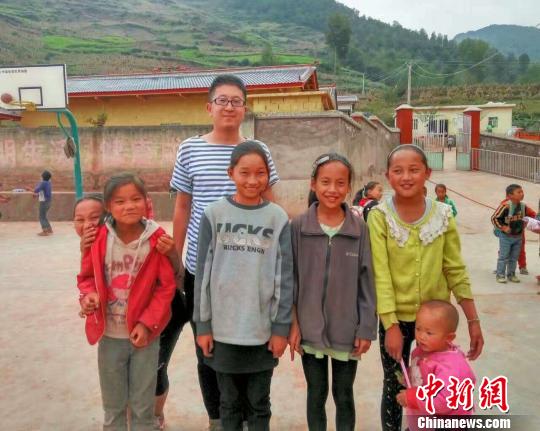 图为杨早龙和大凉山的孩子们在一起。　受访者供图 摄