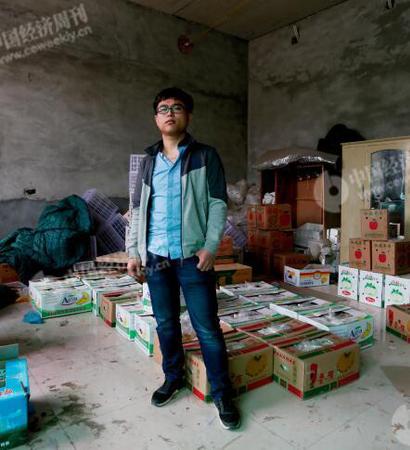 p29-1 程新在自己家中。他的父母在镇上贩卖水果，家中一间暂未装修的房内堆满各种水果。