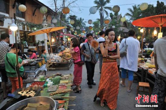 4月13日，云南西双版纳“告庄西双景”内，逛夜市的游客?！案孀魉啊蔽鲇?，意为“九塔十二寨”，位于澜沧江畔，占地1200亩的景区内傣式风格浓郁。自2012年开业至今，年接待游客量已经突破400万人次，2015年春节期间，日均游客人数突破10万人次，成为云南旅游新地标。 <a target='_blank' href='http://www.chinanews.com/'>中新社</a>记者 任东 摄